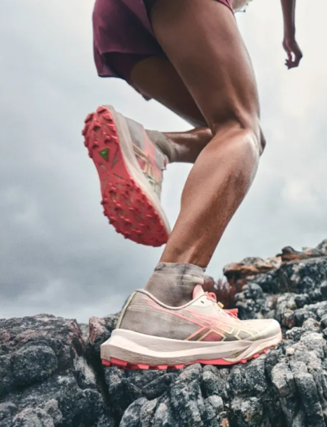 Runner on rocky trail wearing ASICS performance running shoes
